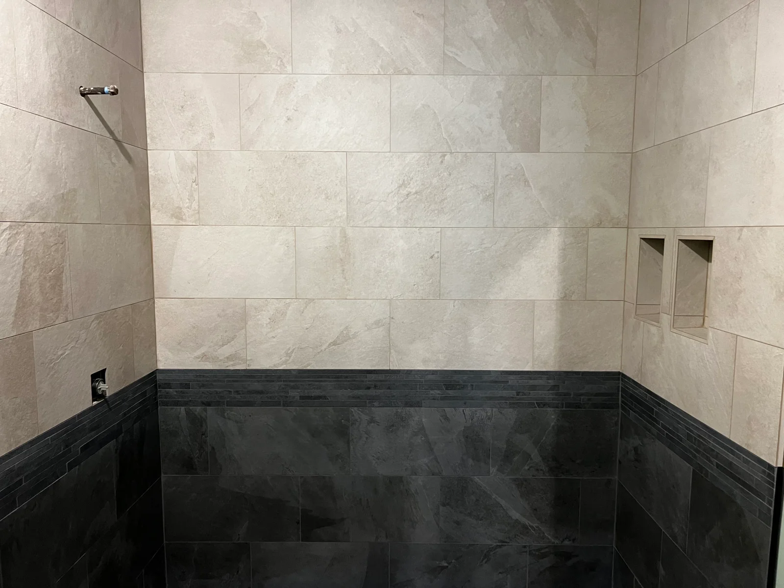 Light marble subway tiles with dark slate lower wall and floor tiles in shower enclosure