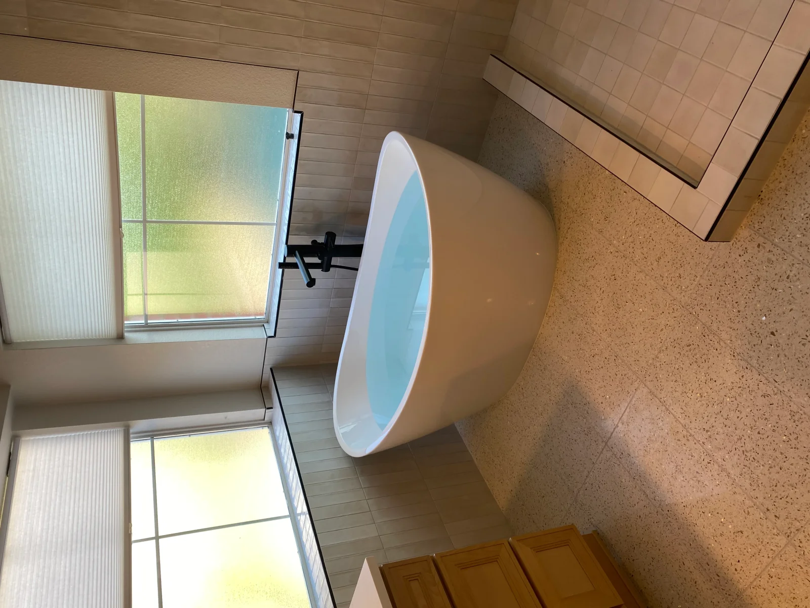 Bathroom with ceramic subway tile walls, cork flooring, and large round mirror with white frame